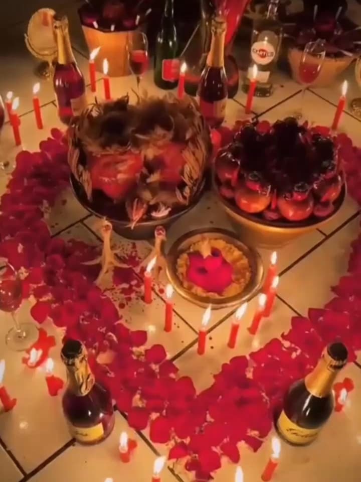 Trabajo de amor en mi altar: un corazón de pétalos de rosa, veladoras rojas y champaña.