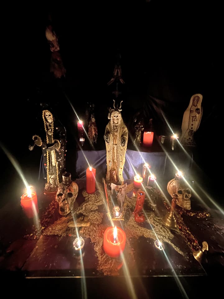 La Santa Muerte en una velación de noche, con veladoras y calaveras.